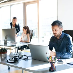 Three business people in the office working together.