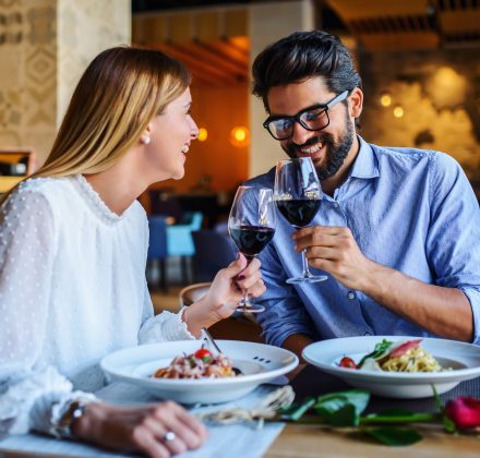 Loving couple enjoying lunch in the restaurant, eating paste and drinking red wine. Lifestyle, love, relationships, food concept